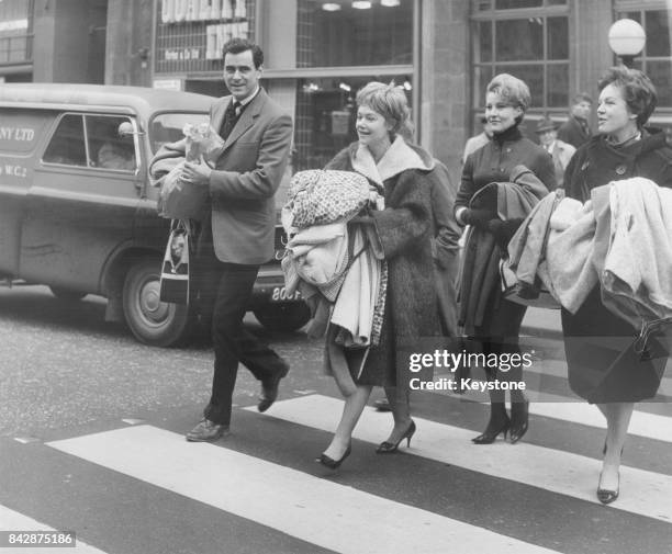 The stars of the West End thriller 'Portrait of Murder' carry their costumes across the road from the Savoy Theatre to the Vaudeville Theatre in...