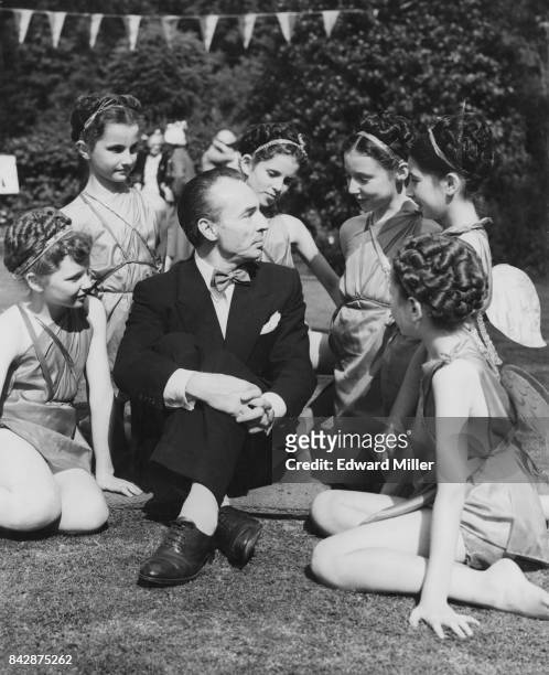Choreographer George Balanchine , Artistic Director of the New York City Ballet, chats to pupils from the Royal Academy of Dancing during a garden...