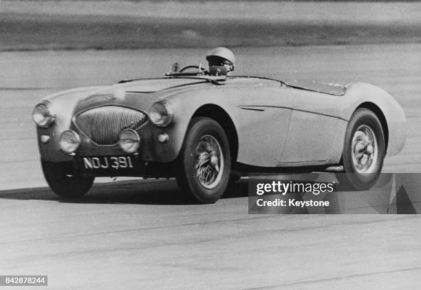 English rally driver and car designer Donald Healey in the Austin-Healey Hundred after setting the new world speed record for production cars on the...