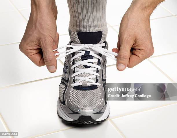 male hands tying sneaker lace - men in white socks 個照片及圖片檔