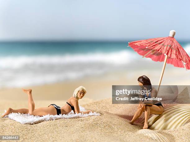 figurines on beach - menschliche darstellung stock-fotos und bilder