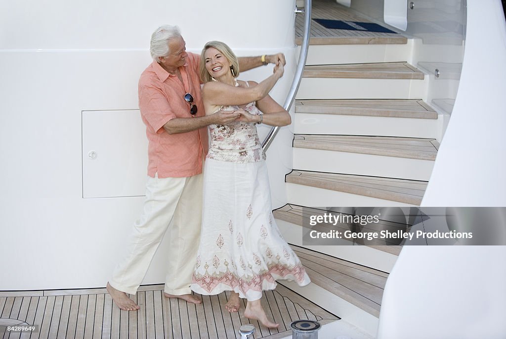 Wealthy senior couple dancing on a yacht