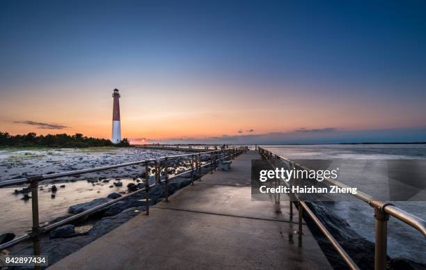 zonsondergang over barnegat vuurtoren - long beach island stockfoto's en -beelden