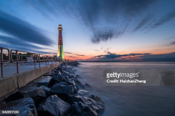 sunset over barnegat lighthouse - new jersey beach stock pictures, royalty-free photos & images