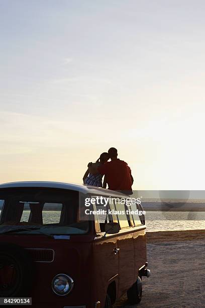 couple watching ocean sunset from top of van - tampa sunset stock pictures, royalty-free photos & images