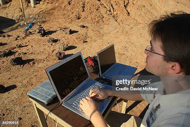 Caltech grad student Jeffrey Edlund teleoperates Axel, a research prototype rover for exploring the Moon, Mars and other planets, over rocks as...