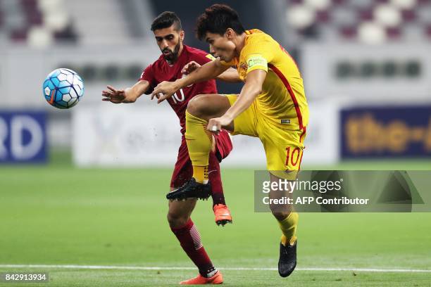 Qatar's forward and captain Hasan al-Haydos vies for the ball against China's captain Zheng Zhi during the FIFA World Cup 2018 qualification football...