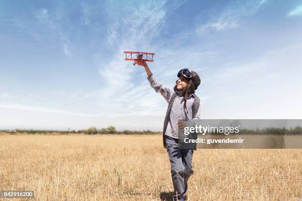 boy playing with toy airplane - aviation hat stock pictures, royalty-free photos & images