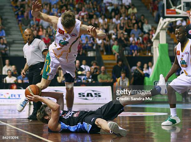 Dillon Boucher of the Breakers looks to pass the ball as Cameron Tovey of the Crocodiles trips over him during the round 18 NBL game between the New...