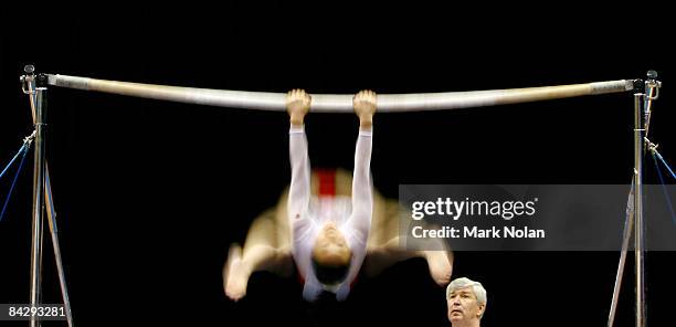 Japanese coach assists an athlete during a routine on the uneven bars during the Artistic Gymnastics on day two of the Australian Youth Olympic...