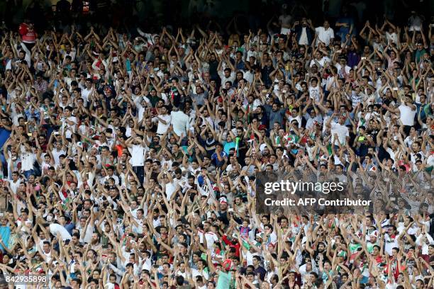 Supporters of Iran cheer for their team during the FIFA World Cup 2018 qualification football match between Iran and Syria at the Azadi Stadium in...