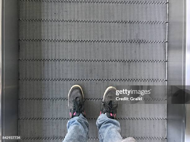 man's foot in airport escalator perspective view - metallic shoe stock pictures, royalty-free photos & images