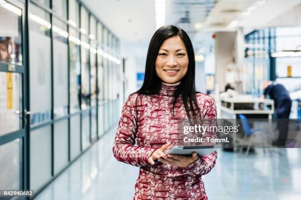 asiatische ingenieur mit digital-tablette in fabrik - female scientist stock-fotos und bilder