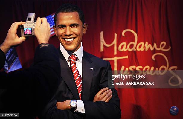 Visitor takes pictures of a wax likeness of incoming US president Barack Obama at Berlin's Madame Tussaud's wax museum on January 15, 2009. When...