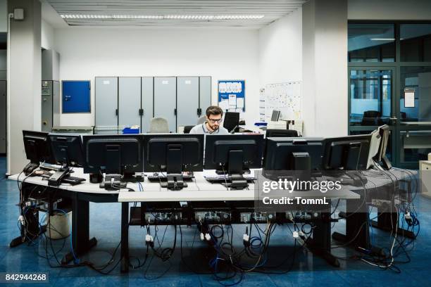 engineer working in big control room - control centre stock pictures, royalty-free photos & images