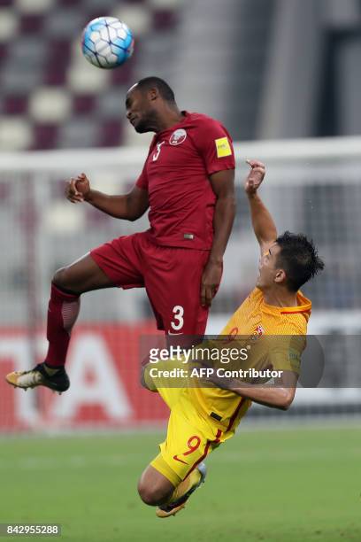 China's Xiao Zhi and Qatar's Abdelkarim Hassan fight for the ball during the FIFA World Cup 2018 qualification football match between Qatar and China...