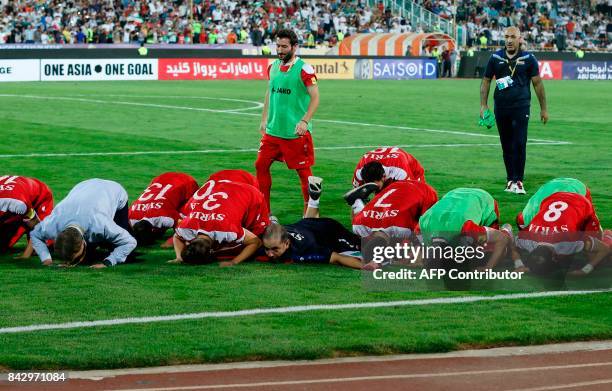 Syria's players pray at the end of their FIFA World Cup 2018 qualification football match against Iran at the Azadi Stadium in Tehran on September 5,...