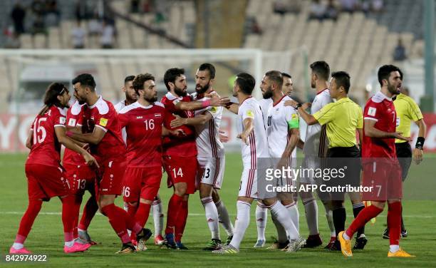 Players scuffle during the FIFA World Cup 2018 qualification football match between Iran and Syria at the Azadi Stadium in Tehran on September 5,...