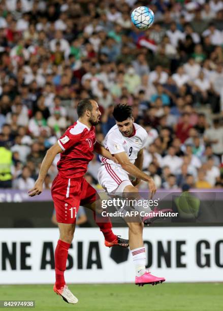 Iran's Mehdi Taremi vies for the ball against Syria's Hadi Almasri during the FIFA World Cup 2018 qualification football match between Iran and Syria...