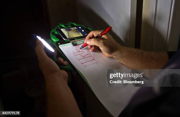 State Farm catastrophe claims adjuster draws a sketch while surveying a home affected by Hurricane Harvey in Rockport, Texas, U.S., on Saturday,...
