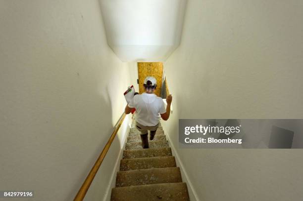 State Farm catastrophe claims adjuster walks down a stairway covered in broken glass at a home affected by Hurricane Harvey in Rockport, Texas, U.S.,...