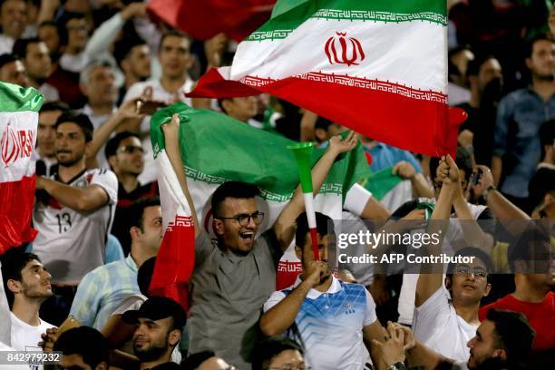 Supporters of Iran cheer for their team during the FIFA World Cup 2018 qualification football between Syria and Iran at the Azadi Stadium in Tehran...