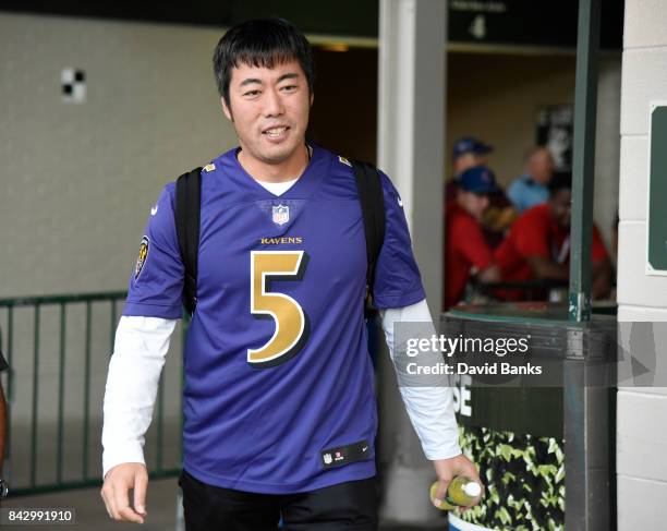 Koji Uehara of the Chicago Cubs wears a football jersey as the Cubs leave on their road trip, on September 3, 2017 at Wrigley Field in Chicago,...