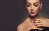 Magnificent lady in a perfect make up is shows jewelry set.