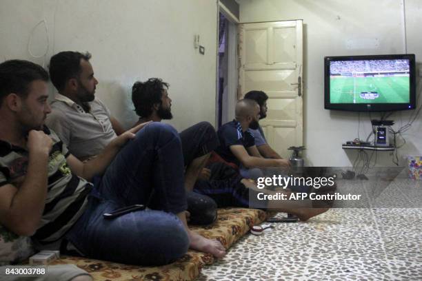 Syrian watch the FIFA World Cup 2018 qualification football match between Iran and Syria, played in Tehran, in the rebel held town of Binnish on the...