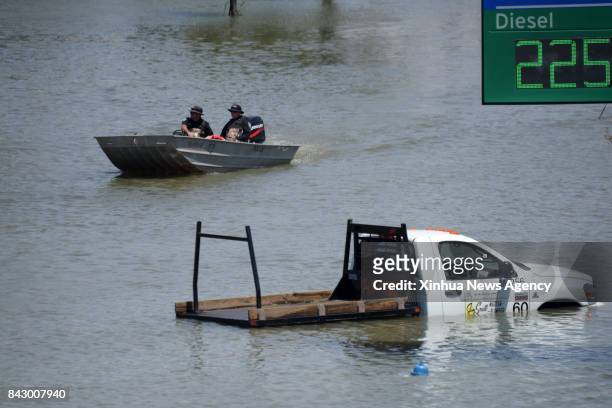 Aug. 31, 2017 -- Rescuers pass by a flooded vehicle in Port Arthur, Texas, the United States, Aug. 31, 2017. Nearly 40 people died or are feared dead...