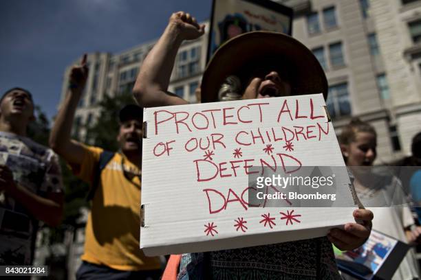 Demonstrator yells while holding a sign protesting the end of the Deferred Action for Childhood Arrivals program outside Trump International Hotel in...