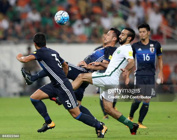 Saudi Arabia's Mohammed Alsahlawi and Japan's Shuji Gen and his teammate Maya Yushida fight for the ball during the FIFA World Cup 2018 qualification...