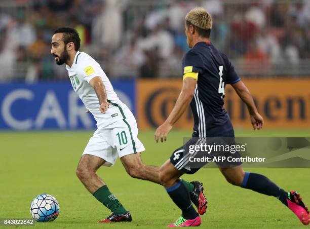 Saudi Arabia's Mohammed Alsahlawi runs with the ball in front of Japan's Keisuki Honda during the FIFA World Cup 2018 qualification football match...