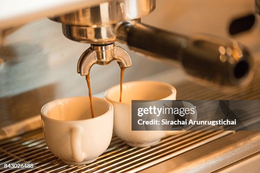 Coffee drips into two coffee cup from Espresso Machine Coffee drips into two coffee cup from Espresso Machine