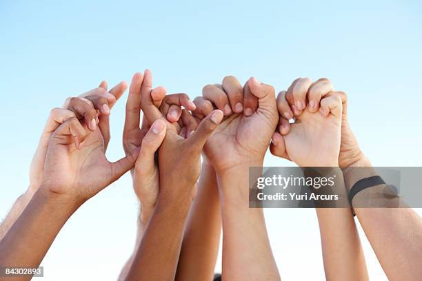 hands clasped in solidarity - hands clasped fotografías e imágenes de stock
