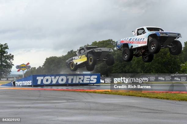 Robby Gordon leads Jeff Hoffman:1 over a jump during the SPEED Energy Stadium Super Trucks Race at Watkins Glen International on September 3, 2017 in...