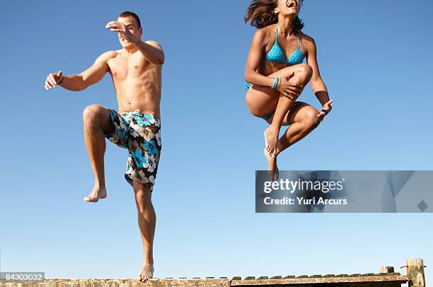 young couple jumping of dock - summer denmark stock pictures, royalty-free photos & images