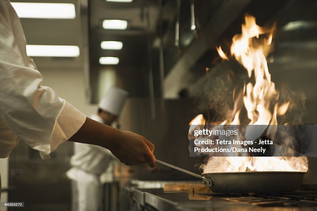 Chef holding flaming pan