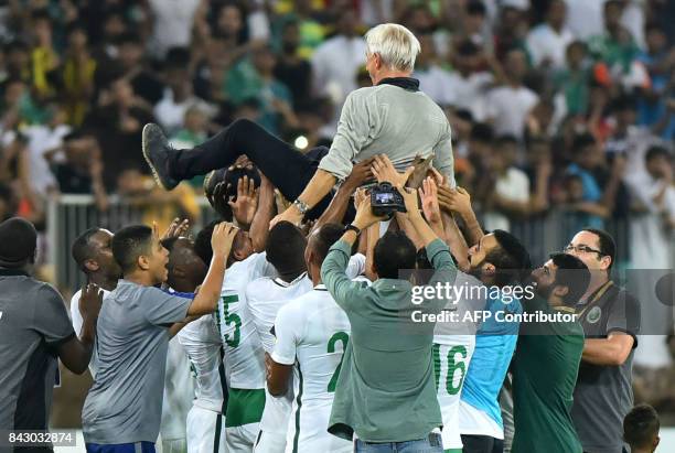 Members of Saudi Arabia's football team carry head coach Bert van Marwijk as they celebrate at the end of the FIFA World Cup 2018 qualification...