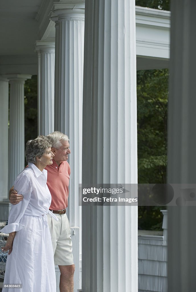 Senior couple standing on front porch