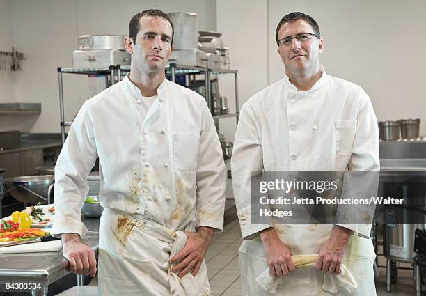 dirty chefs posing in kitchen - chefs whites stock pictures, royalty-free photos & images