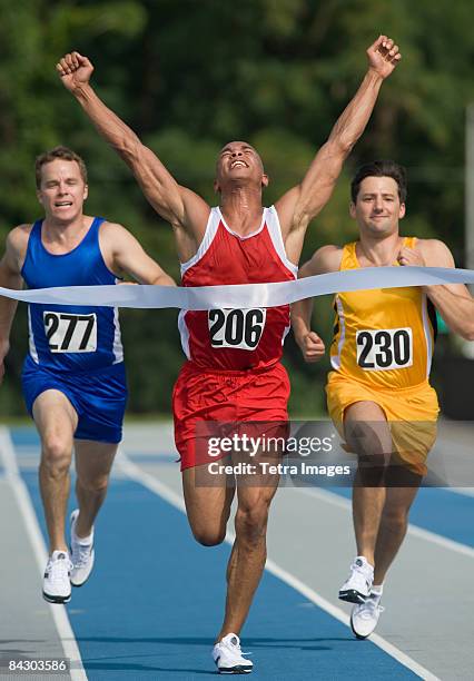 runner breaking through finish line - live finale stock pictures, royalty-free photos & images