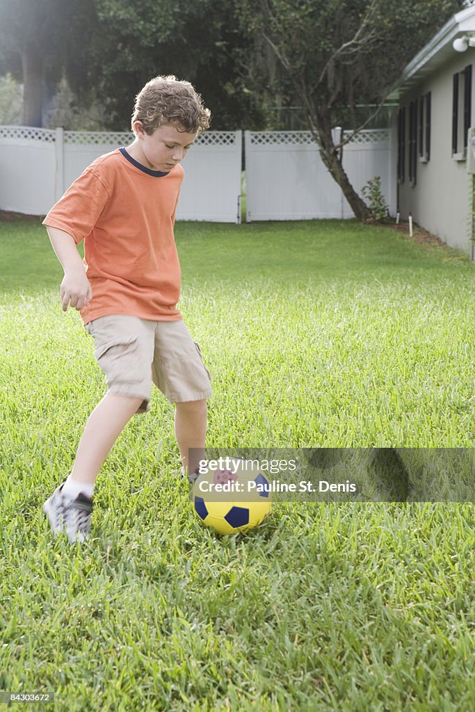 Boy playing in soccer in backyard