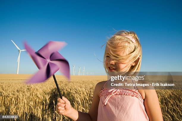 girl holding pinwheel on wind farm - windrad stock-fotos und bilder