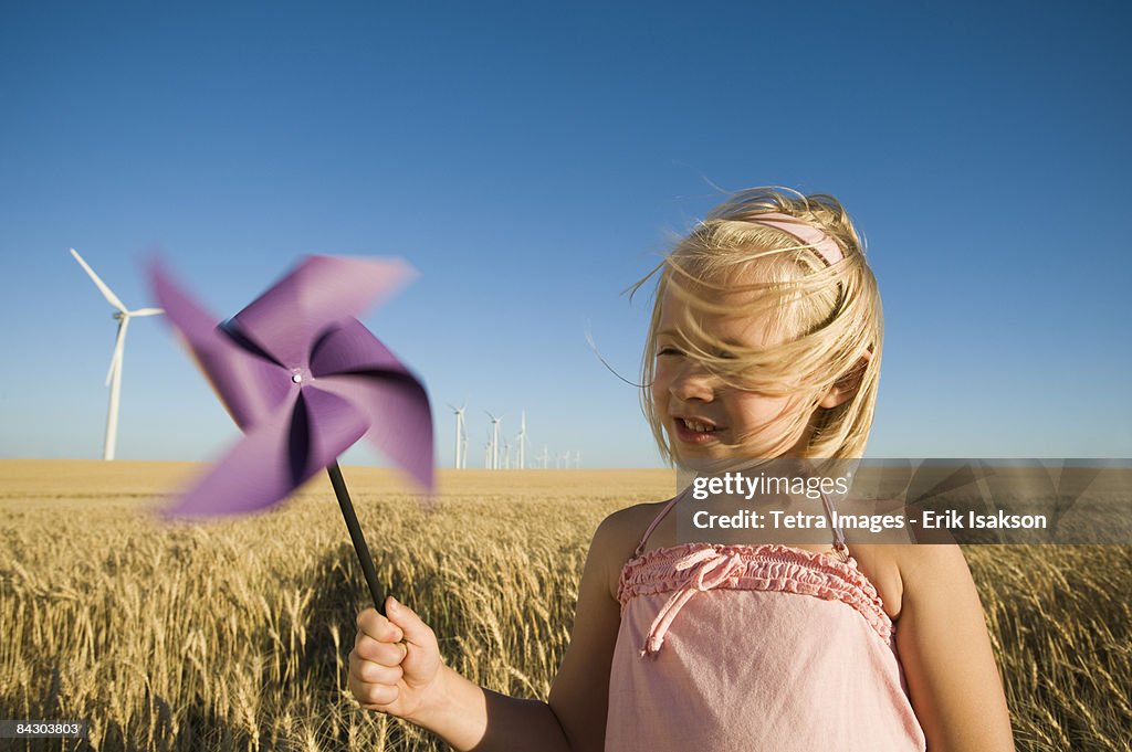 Girl holding pinwheel on wind farm
