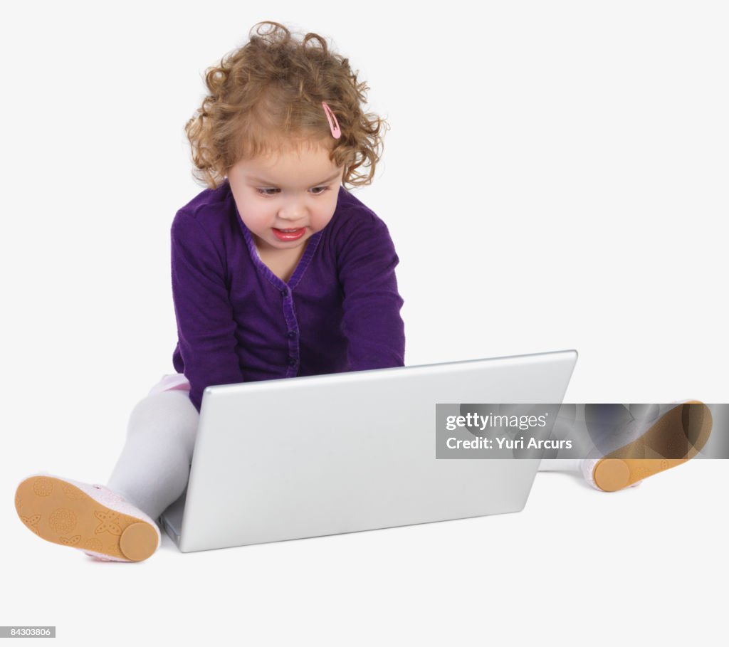 Preschool girl playing with laptop