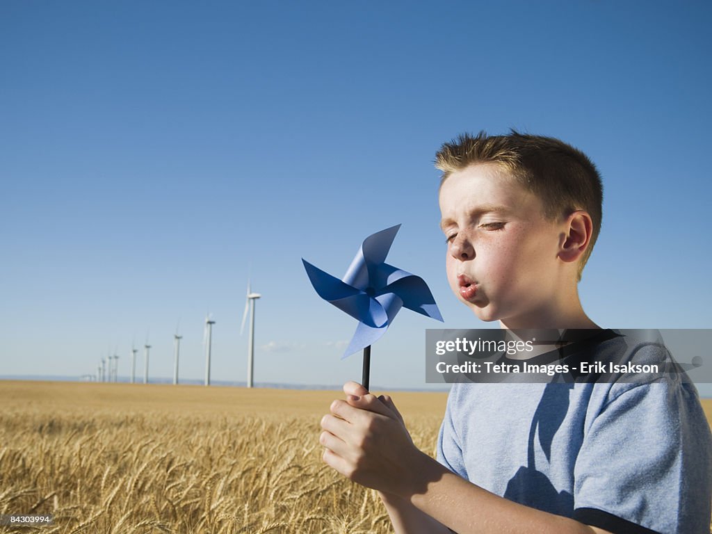 Boy holding pinwheel on wind farm