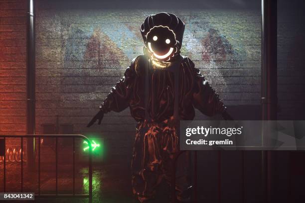 smiling hazmat suit man in the streets at night - dark alley stock pictures, royalty-free photos & images