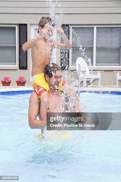 father and son splashing in swimming pool - tampa house stock pictures, royalty-free photos & images