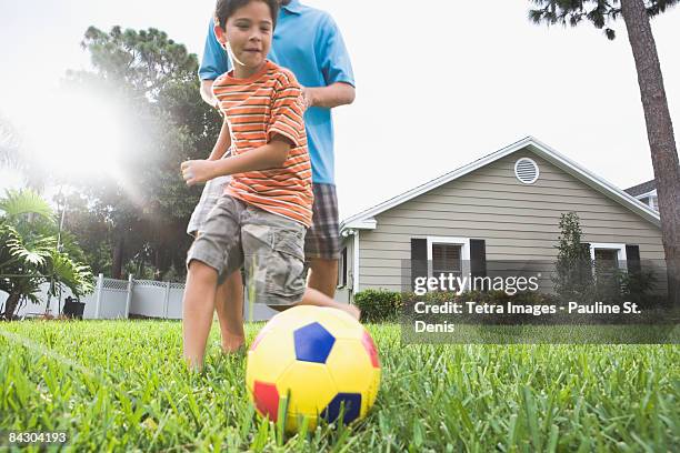 father and son playing soccer in backyard - tampa homes stock pictures, royalty-free photos & images